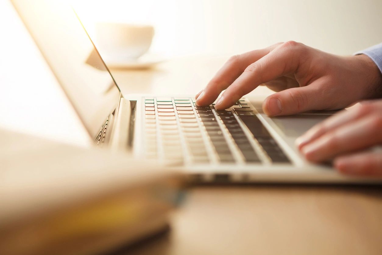 A person typing on a laptop computer.