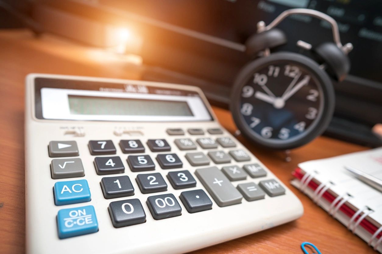 A calculator sitting on top of a wooden table.